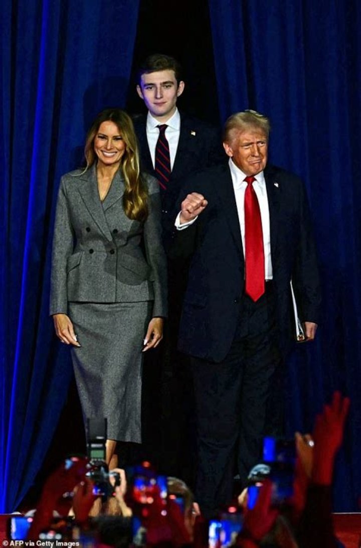 Barron Trump, 13, towers over his parents Donald and Melania Herald Sun